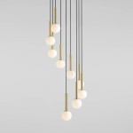 Lampa wisząca Riu 9-punktowa, czarna z mosiężnymi detalami. Posiada dziewięć okrągłych, białych kloszy zawieszonych na cienkich, czarnych przewodach, w różnej długości. Ujęcie z góry, na jednolitym tle.