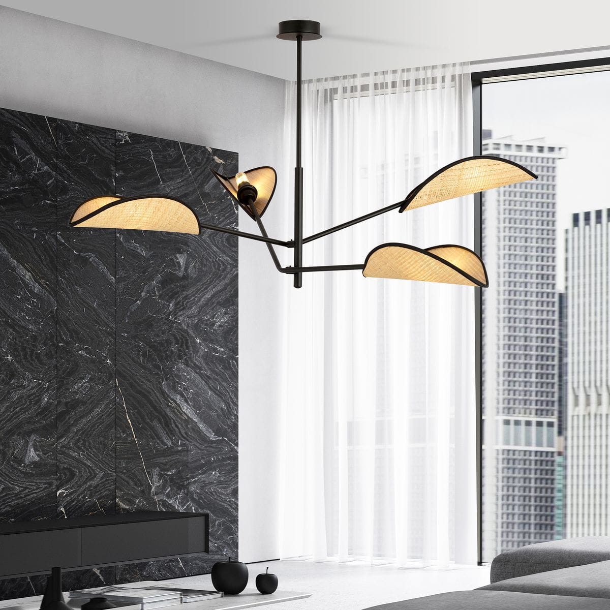 Czarna lampa sufitowa 4-punktowa z rattanowymi kloszami w kształcie liści. Ujęcie z dołu, pokazujące lampę wiszącą w nowoczesnym wnętrzu z szarym tłem. Klosze emitują ciepłe światło, a konstrukcja ma minimalistyczny design.