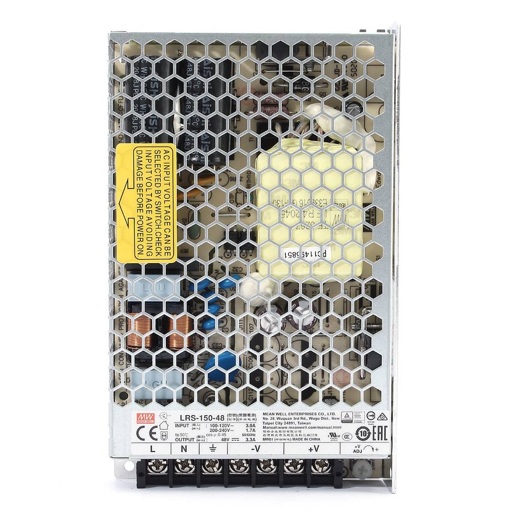 Zasilacz zewnętrzny do szyn magnetycznych 150W/48VDC w metalowej obudowie z siatką wentylacyjną. Widoczne złącza na dolnej części, etykieta informacyjna oraz komponenty wewnętrzne, takie jak kondensatory i transformatory.