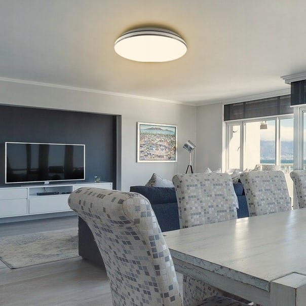 Plafon Kiro LED D33 w kolorze białym z chromowanym wykończeniem, o mocy 18W i barwie światła 4000K, zamontowany na suficie w nowoczesnym wnętrzu, z widocznym stołem i sofą w tle.