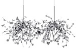 Lampa wisząca Monete 6-punktowa w chromie, o organicznej formie z metalicznymi detalami. Wyposażona w sześć źródeł światła, zawieszona na cienkich linkach. Wzór składający się z okrągłych elementów, tworzący efekt pnącza. Tło białe.