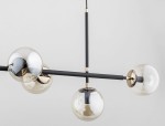 Primo lampa wisząca 6-punktowa w kolorze czarnym i złotym. Posiada sześć szklanych kloszy w formie kul, zamontowanych na czarnych prętach. Ujęcie z boku, prezentujące detale konstrukcji i połysk kloszy.