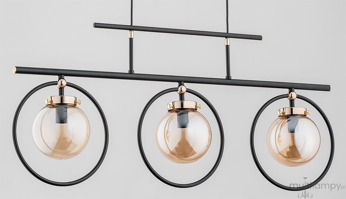 Lampa wisząca Vasido 3-punktowa w kolorze czarnym i złotym. Trzy szklane klosze w formie kul, zawieszone w okręgach, na prostokątnej metalowej konstrukcji. Ujęcie z przodu, na jednolitym tle.