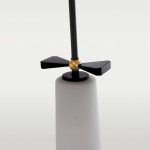 Lampa wisząca Bow w kolorze czarnym i mosiądzu, z matowym kloszem w kształcie stożka. U góry widoczny element z trzema łopatkami w kolorze czarnym oraz złotą kulą. Produkt zawieszony na cienkiej, czarnej rurze.