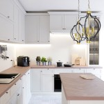 Lampa wisząca Nashville 5-punktowa w kolorze czarnym z elementami złotymi, zawieszona nad drewnianym blatem w nowoczesnej kuchni. W tle widoczne białe szafki, rośliny w doniczkach oraz sprzęt AGD.