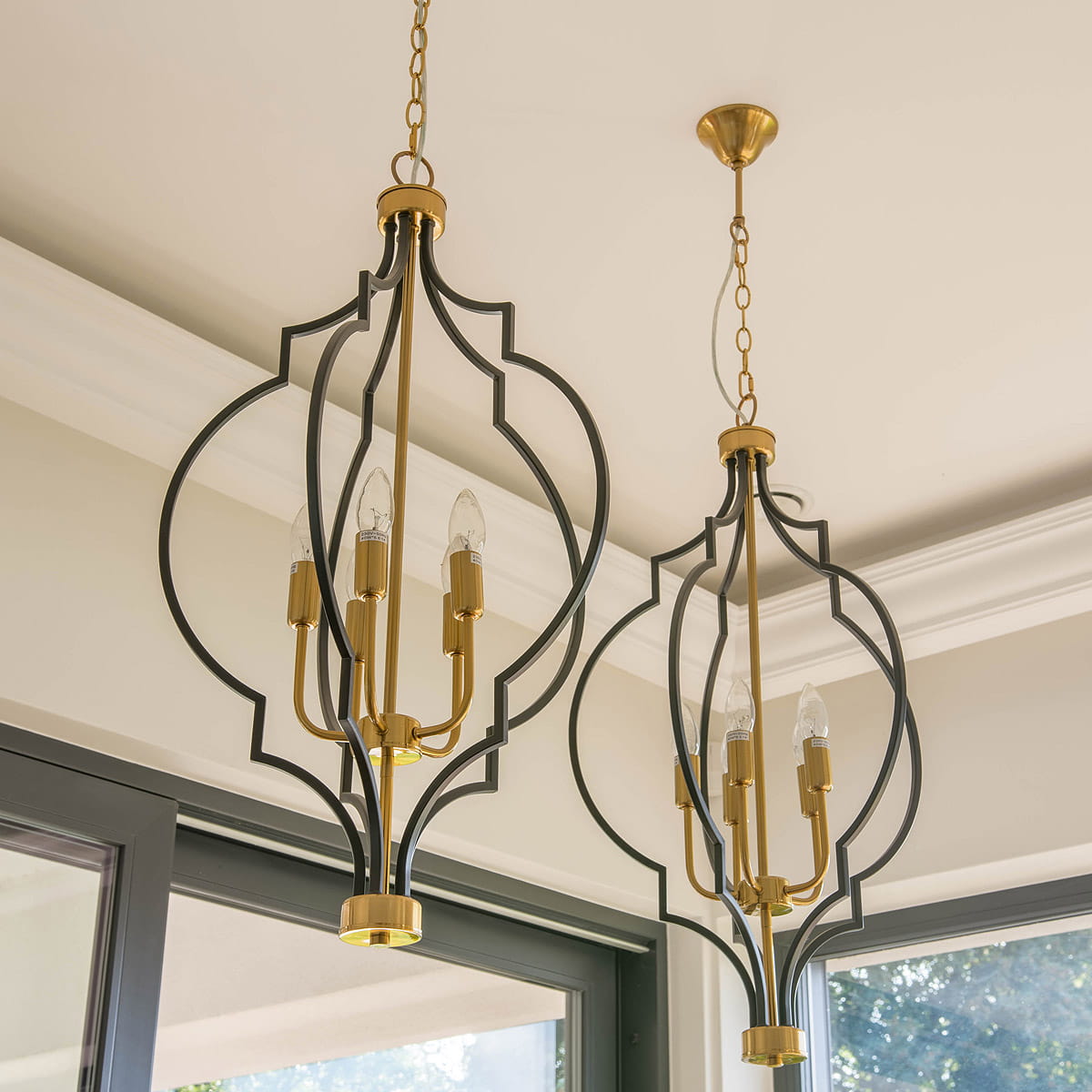Lampa wisząca Nashville 5-punktowa w kolorze czarnym i złotym, z dekoracyjnym metalowym stelażem w kształcie owalnym, zawieszona na łańcuchu. Widoczne pięć źródeł światła w eleganckich oprawach. Tło jasne, z naturalnym oświetleniem.