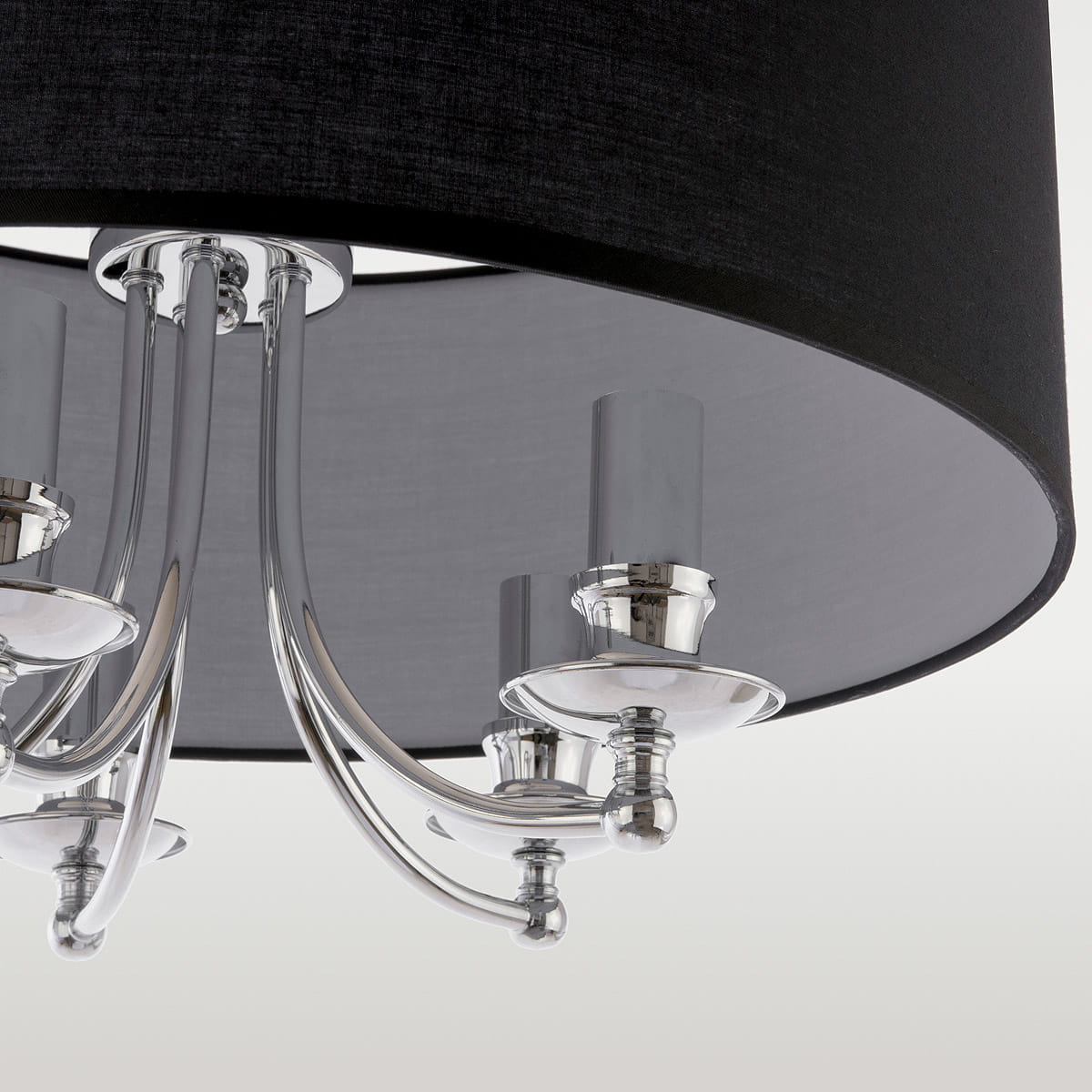 Lampa wisząca Abu Dhabi 5-punktowa w kolorze chromu i czerni. Posiada elegancką, okrągłą, czarną abażur i pięć chromowanych ramion z przejrzystymi osłonami na żarówki, wisząca w pozycji centralnej.