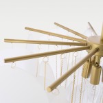 Złota lampa wisząca Tromso z pięcioma punktami świetlnymi, z metalowymi ramionami w kształcie promieni. Wisi na łańcuchach, z przezroczystymi kloszami, tworząc nowoczesny design. Ujęcie z góry, pokazujące szczegóły konstrukcji i wykończenia.