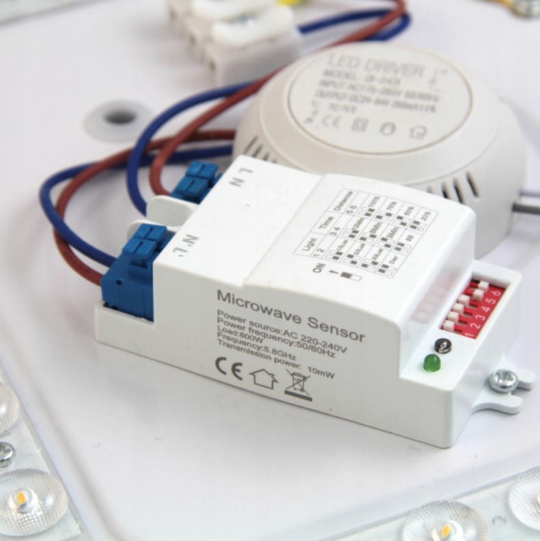 Plafon Kiro LED D38 z czujnikiem ruchu, biały, z chromowanymi detalami. Widoczny czujnik mikrofalowy z przewodami, oznaczeniami i diodą LED, umieszczony na tle białej podstawy. Wbudowane oświetlenie LED o mocy 24W i temperaturze barwowej 4000K.