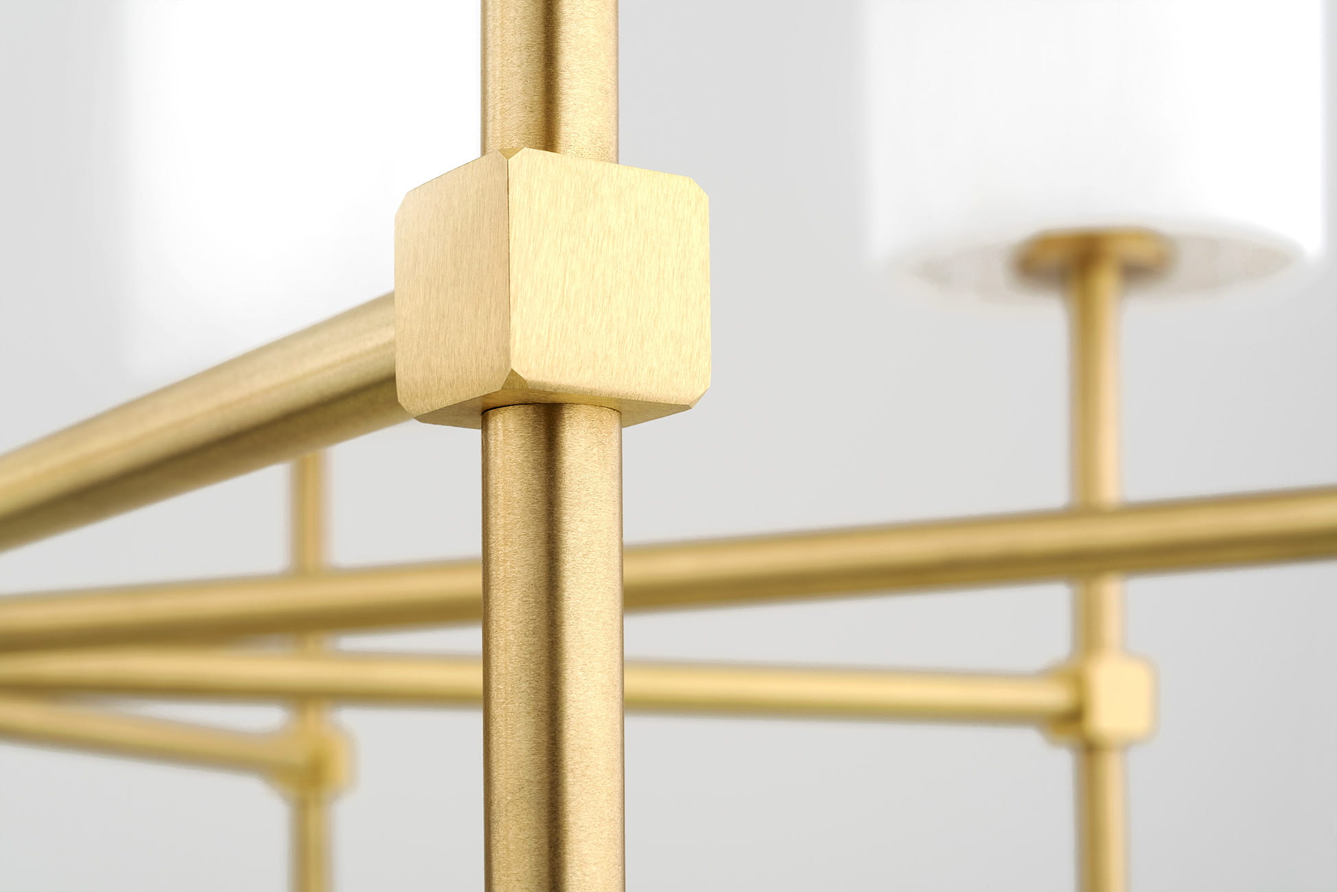 Lampa wisząca Abruzzo 5-punktowa w kolorze białym z metalową, złotą konstrukcją. Widoczne detale to prostokątne mocowanie, gładkie metalowe pręty oraz białe klosze, co tworzy nowoczesny wygląd. Produkt ukazany z bliska, akcentujący teksturę materiałów.