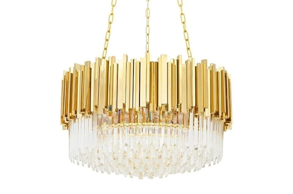 Złota lampa wisząca Imperial D60 z 12 punktami świetlnymi, o okrągłym kształcie. Górna część składa się z prostokątnych elementów w złotym kolorze, dolna z kryształowych pryzmatów. Lampa zawieszona na złotym łańcuchu, z subtelnym blaskiem.