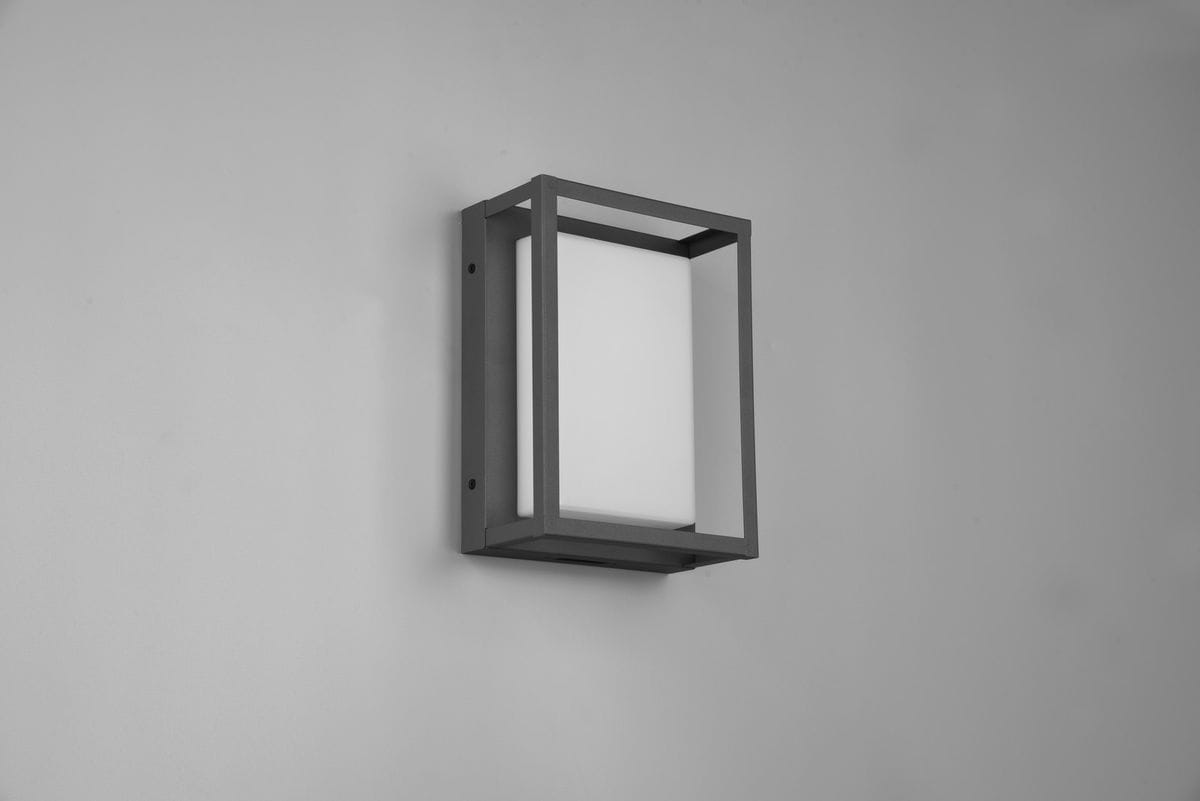 Kinkiet zewnętrzny Witham LED w kolorze antracytowym, o prostokątnym kształcie. Montowany na ścianie, z białym, mlecznym kloszem. Wyposażony w jedną oprawę, prezentowany frontalnie na gładkiej ścianie.