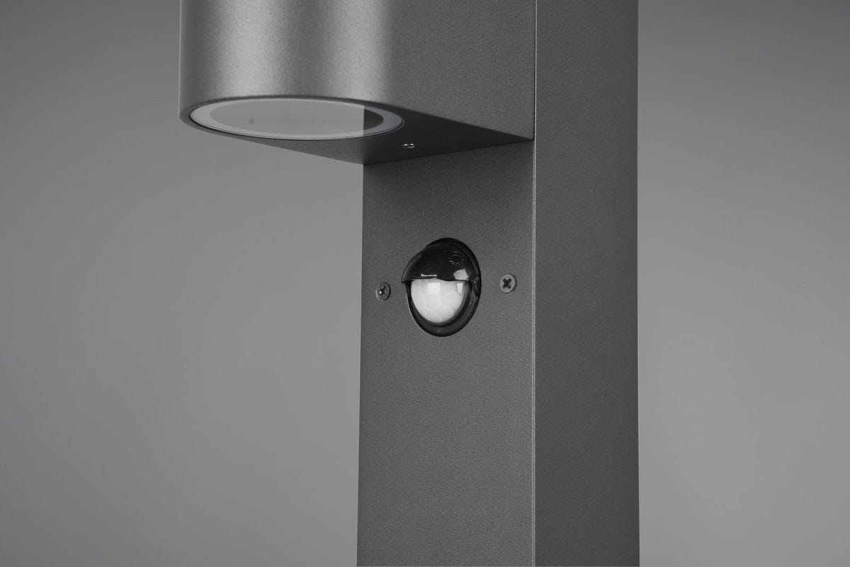 Lampa stojąca ogrodowa Roya H100 w kolorze antracytowym, z czujnikiem ruchu. Ujęcie z boku, ukazujące cylindryczną głowicę oraz zaokrąglony czujnik. Prosty, nowoczesny design, idealna do oświetlenia przestrzeni zewnętrznej.