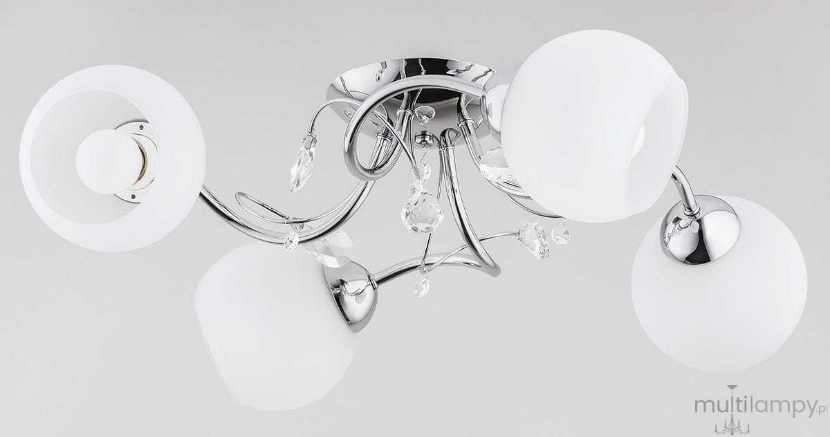 Livia Pro lampa sufitowa 4-punktowa z chromowanym stelażem, posiada cztery okrągłe klosze z białego szkła. W centralnej części dekoracyjne elementy kryształowe. Ujęcie z góry, lampa zamontowana na suficie.
