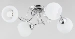 Livia Pro lampa sufitowa 4-punktowa z chromowanym stelażem, posiada cztery okrągłe klosze z białego szkła. W centralnej części dekoracyjne elementy kryształowe. Ujęcie z góry, lampa zamontowana na suficie.