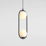 Lampa wisząca Riva 2-punktowa w kolorze czarnym, z dwoma okrągłymi kloszami w odcieniu białym, zawieszona na cienkim przewodzie. Kształt lampy jest prostokątny z zaokrąglonymi krawędziami, w minimalistycznym stylu. Tło jednolite, jasne.