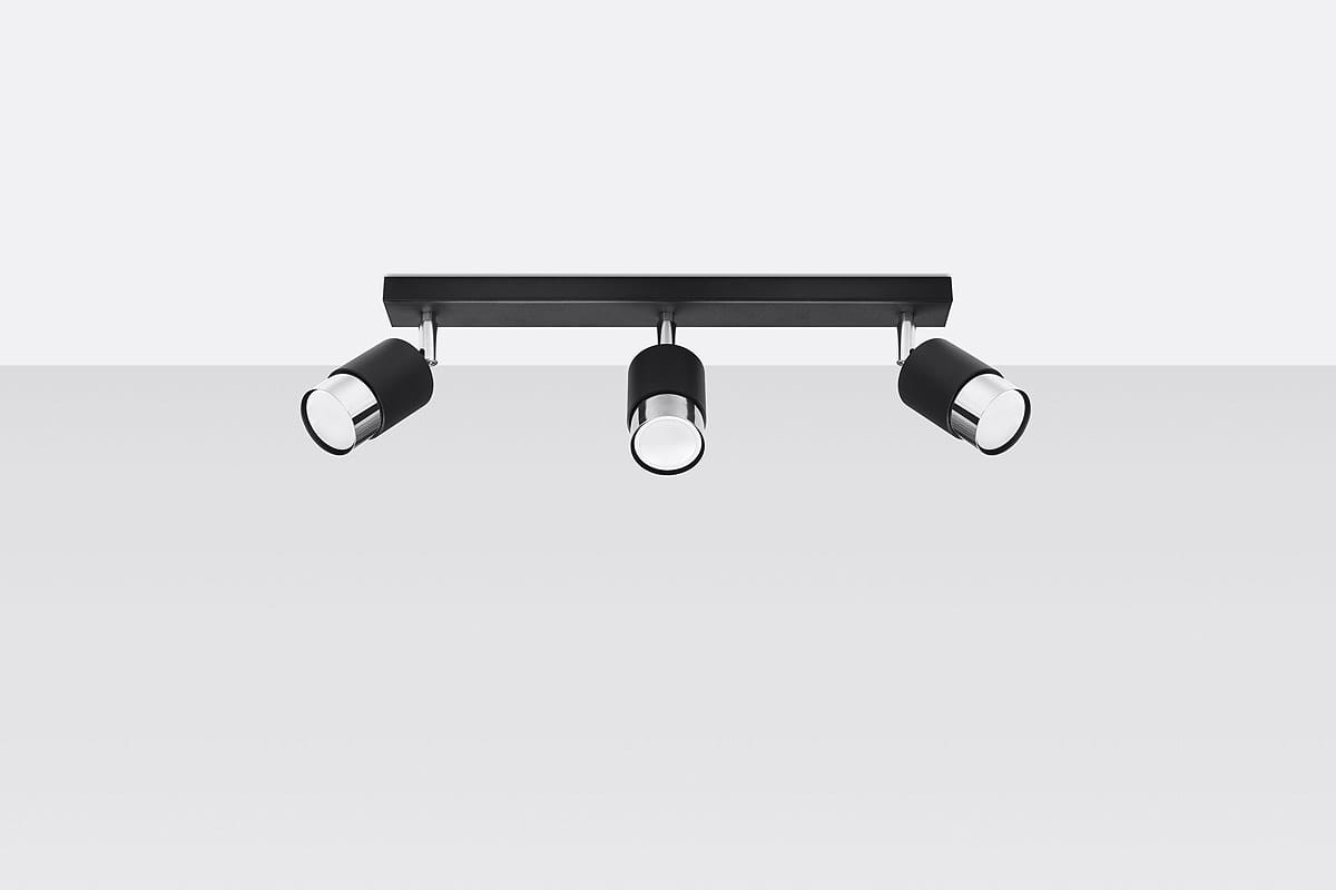 Czarna lampa sufitowa (spot) 3-punktowa z chromowanymi detalami, zamontowana na prostokątnej bazie. Reflektory mają cylindryczny kształt i są ustawione w różnych kierunkach, co pozwala na regulację oświetlenia w pomieszczeniu.