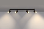 Czarna lampa sufitowa (spot) 4-punktowa z złotymi detalami, zamontowana na płaskiej podstawie. Reflektory są skierowane w dół, co podkreśla ich okrągły kształt i kontrastującą fakturę. Tło jest jednolite, co uwydatnia produkt.