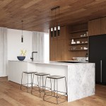 Czarna lampa wisząca Borgio 1-punktowa, umieszczona nad wyspą kuchenną. Posiada prosty, cylindryczny kształt. W tle widoczna elegancka kuchnia z drewnianym sufitem, białą wyspą i krzesłami o metalowej konstrukcji.