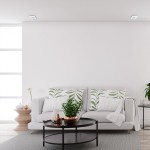 Nusa Square oprawa do zabudowy 1-punktowa w kolorze białym, zamontowana w suficie, minimalistyczny design, idealna do oświetlenia wnętrz. W tle widoczny nowoczesny salon z kanapą, stolikiem i roślinnością.