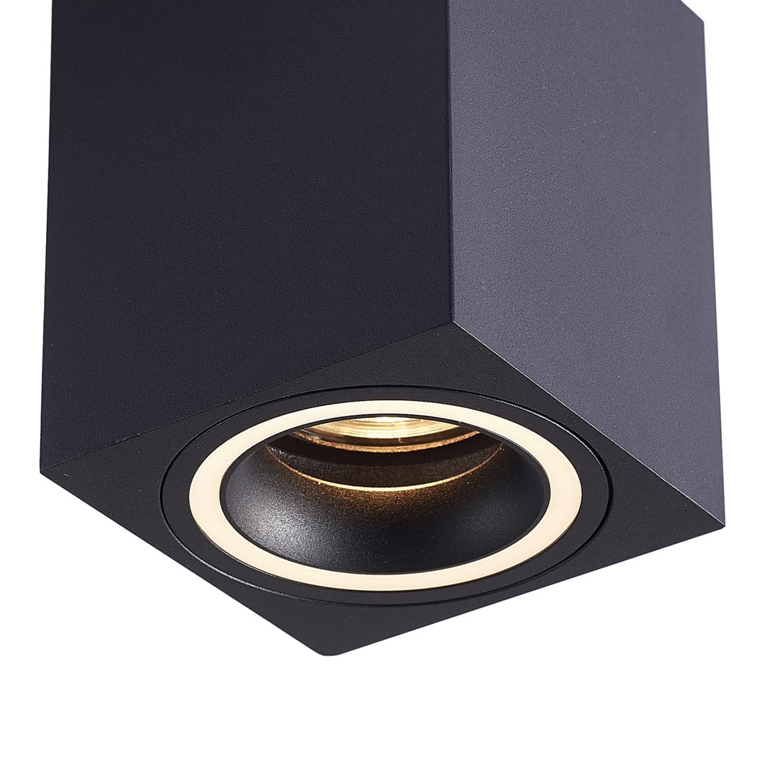 Czarna lampa sufitowa Bima Ring Square o kwadratowej konstrukcji. Zbliżenie na oprawę z okrągłym wnętrzem, ukazującym źródło światła. Matowa faktura obudowy, minimalistyczny design, idealna do nowoczesnych wnętrz.