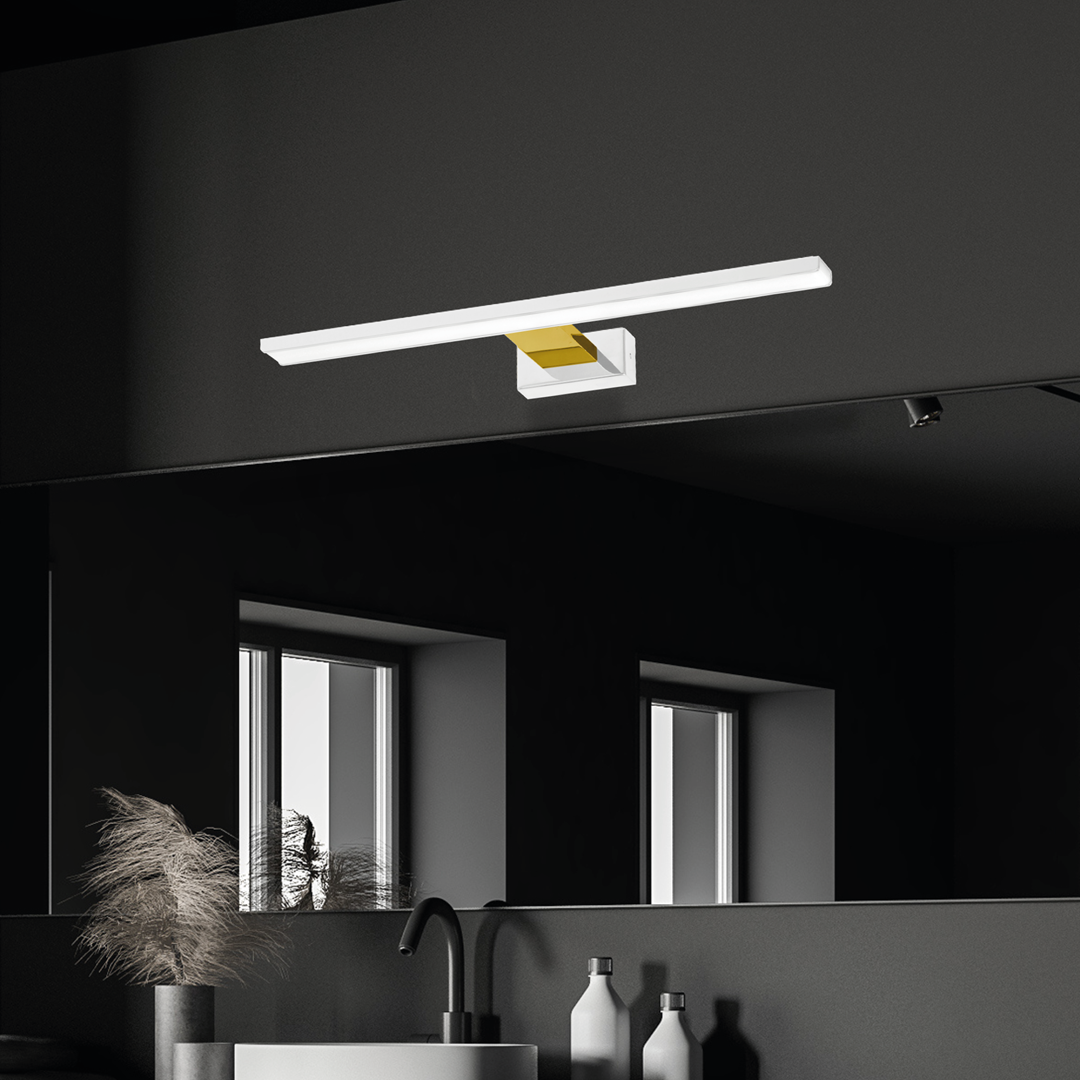 Kinkiet Shine LED IP44 w kolorze białym ze złotym akcentem, o długości 60 cm i mocy 13,8W. Montowany na ścianie, w nowoczesnym stylu, umieszczony nad lustrem w łazience, w minimalistycznym, ciemnym wnętrzu.