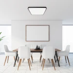 Plafon Fabio LED 35W w kolorze czarnym, o kwadratowym kształcie, zamontowany na suficie w nowoczesnym wnętrzu. Produkt o minimalistycznym designie, oświetlający stół z białymi krzesłami w jasnym pomieszczeniu.