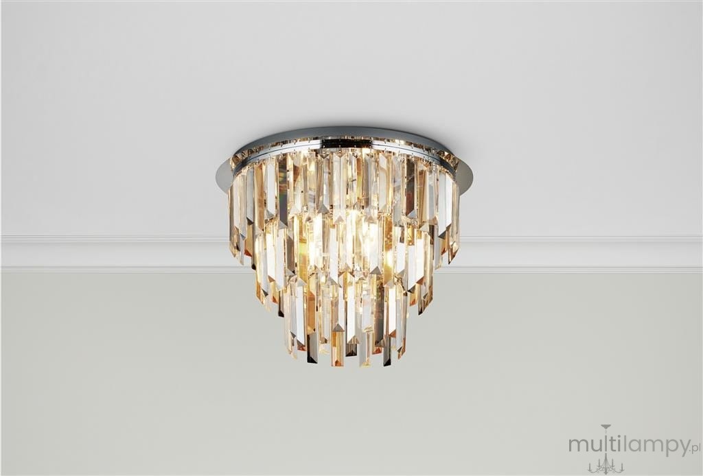 Lampa sufitowa Clarissa 5-punktowa w chromie z kryształowymi elementami. Okrągła, montowana na suficie, z wiszącymi kryształami w różnych odcieniach, emitującymi ciepłe światło. Prosta, elegancka forma, idealna do nowoczesnych wnętrz.