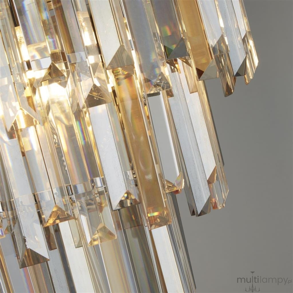 Lampa sufitowa Clarissa 5-punktowa w kolorze chromu, z transparentnymi, szklanymi elementami w kształcie prostokątów i trójkątów, które odbijają światło, tworząc efektowne refleksy. Widok z bliska na detale kryształów.