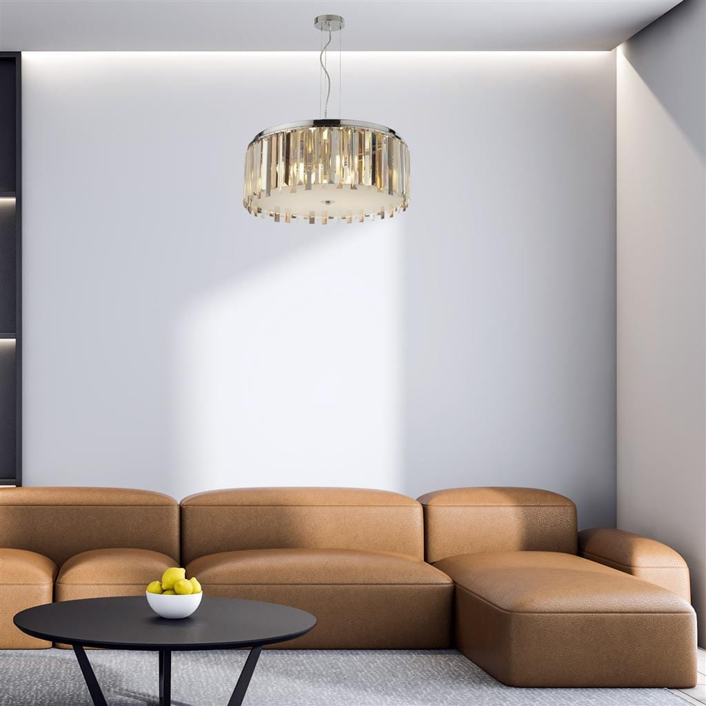 Lampa wisząca Clarissa 5-punktowa w kolorze chromu, okrągła, z wiszącymi elementami dekoracyjnymi. Zawieszona na cienkim przewodzie w nowoczesnym wnętrzu z brązową sofą i czarnym stołem, tworzy elegancki akcent.