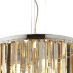Lampa wisząca Clarissa 5-punktowa w chromowanej oprawie, z przezroczystymi, prostokątnymi kryształkami, zawieszona na cienkim przewodzie. Wnętrze lampy oświetlone pięcioma żarówkami, tworzy elegancką atmosferę.