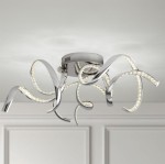 Twirls LED lampa sufitowa 3-punktowa w kolorze chromu, z elastycznymi, spiralnymi ramionami. Lampa montowana na suficie, z widocznymi diodami LED wzdłuż krawędzi ramion. Tło jasne, neutralne.