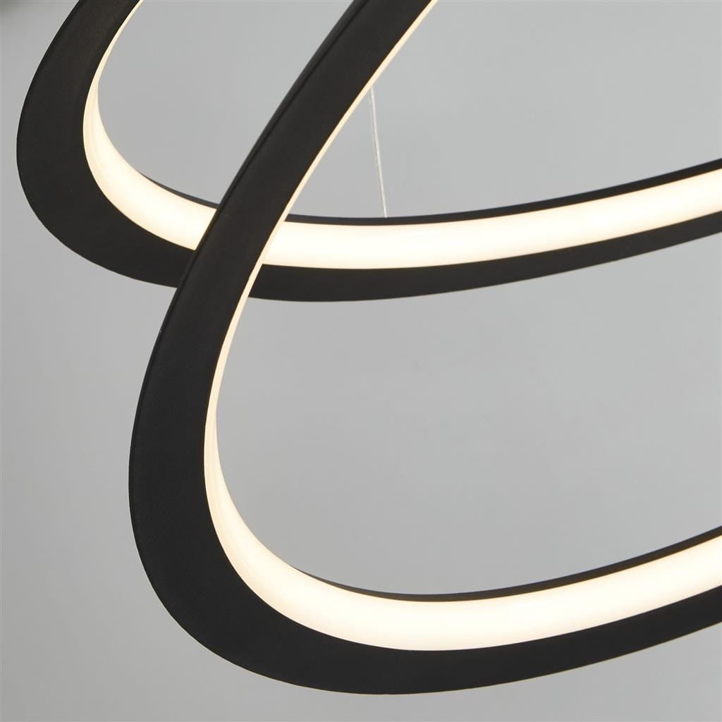 Czarna lampa wisząca Swirl II LED z jednopunktowym mocowaniem, składająca się z dwóch zakrzywionych elementów, z białym, podświetlającym paskiem LED. Ujęcie zbliżeniowe, ukazujące detal i kształt lampy na jasnym tle.