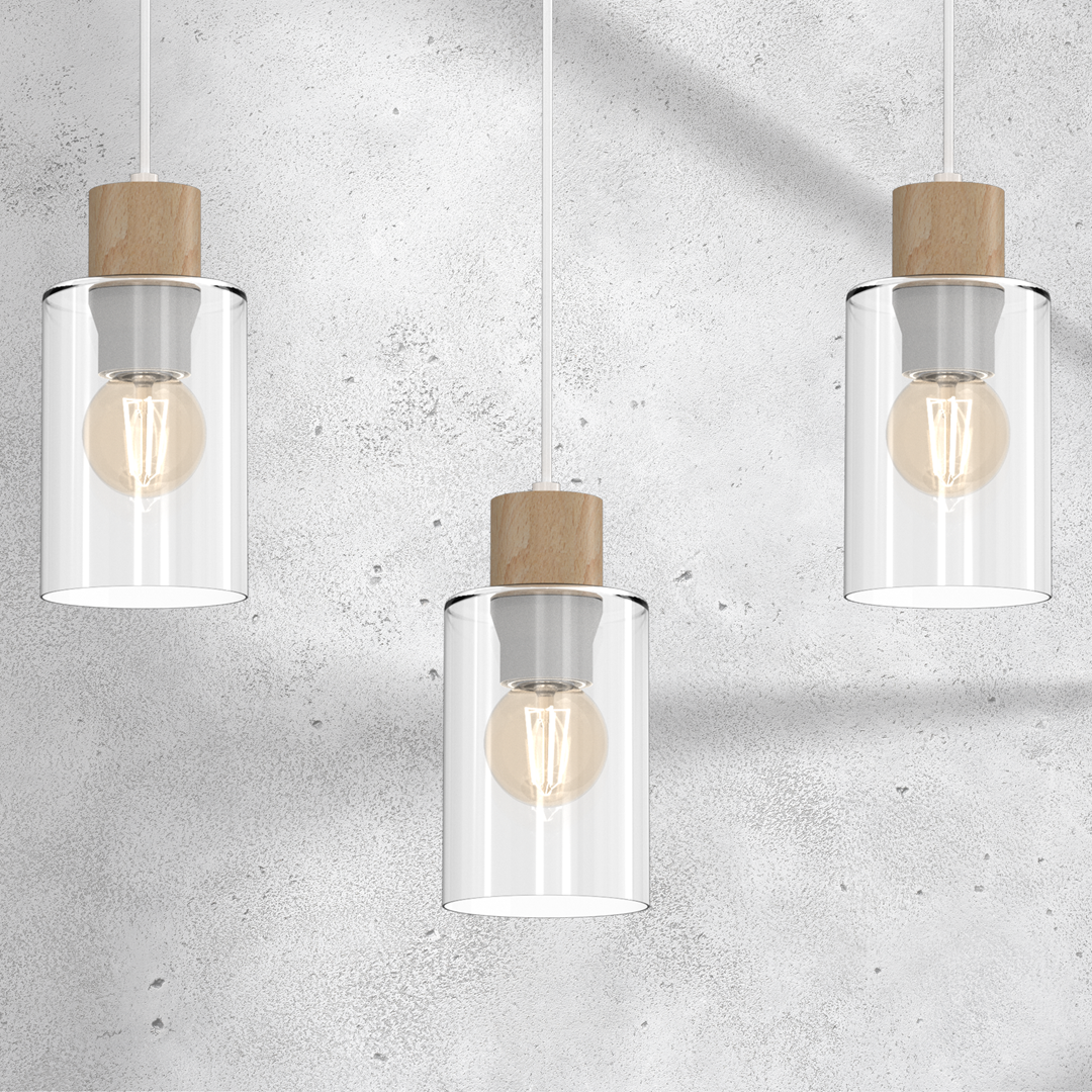 Biała lampa wisząca Madera z trzema kloszami, każdy z przezroczystego szkła, z drewnianymi uchwytami. Klosze mają okrągły kształt, a w środku widoczne żarówki. Produkt zawieszony na białych linkach, na tle szarej, teksturowanej ściany.
