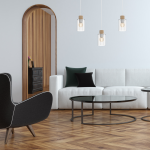 Lampa wisząca Madera 3-punktowa w białych szklanych kloszach z drewnianymi detalami. Zawieszona w nowoczesnym wnętrzu, nad białą sofą i okrągłym stolikiem, w jasnym pomieszczeniu z drewnianymi akcentami.