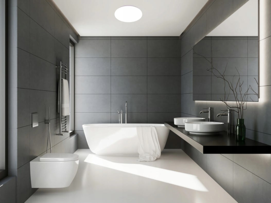 Biały plafon LED Erik D25 o mocy 12W i temperaturze barwowej 4000K, umieszczony w nowoczesnej łazience z szarymi płytkami. Oświetlenie sufitowe, okrągły kształt, z wysokim stopniem ochrony IP44.