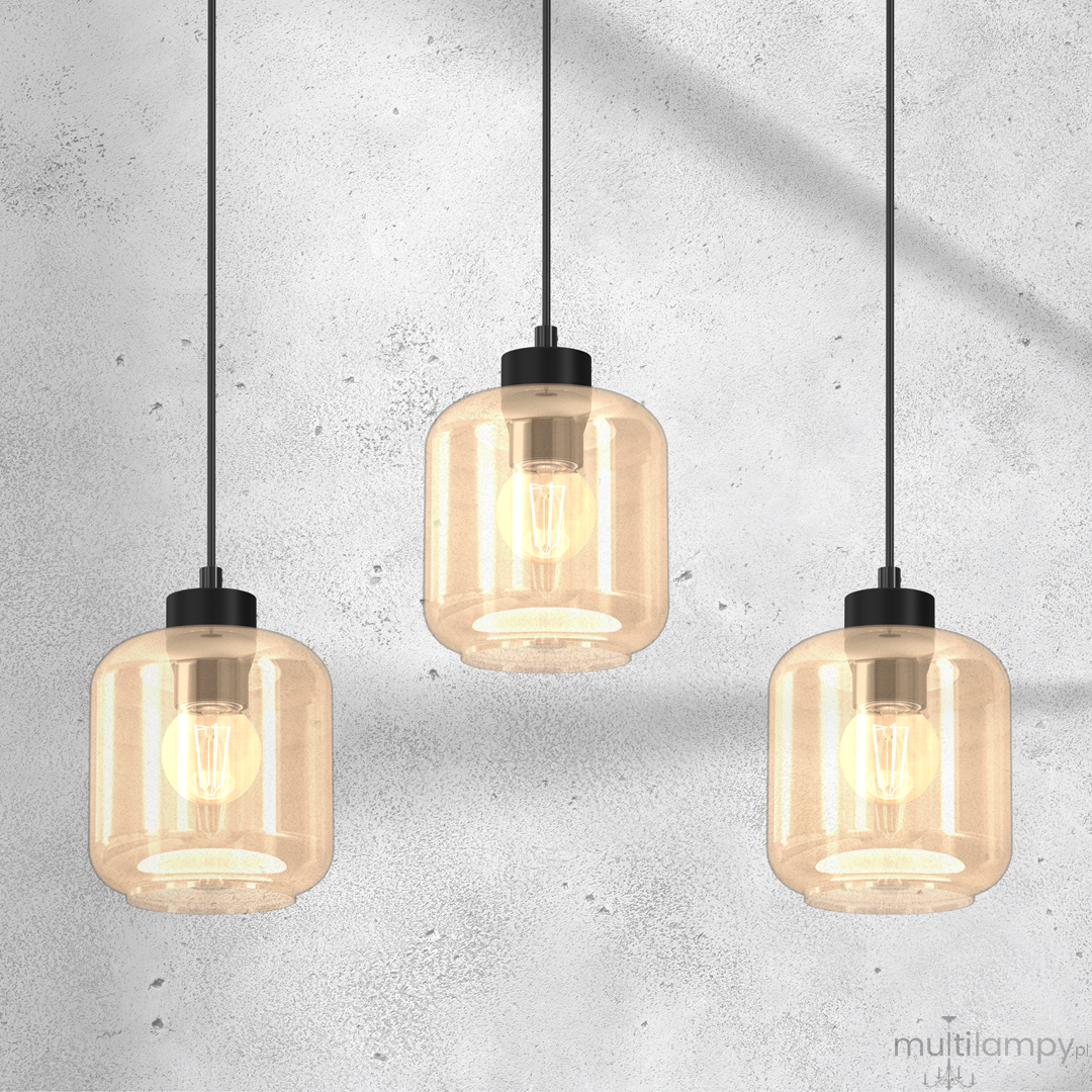 Lampa wisząca Sombra 3-punktowa w kolorze czarnym i bursztynowym. Szklane klosze w kształcie cylindrów z widocznymi żarówkami, zawieszone na czarnych przewodach. Tło w odcieniu szaro-białym.