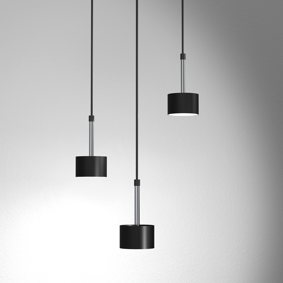 Trzy-punktowa lampa wisząca Arena w kolorze czarnym i srebrnym z cylindrycznymi kloszami. Klosze zawieszone na cienkich, czarnych przewodach, z metalowymi detalami. Oświetlenie skierowane w dół, na jednolitym tle.