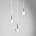 Lampa wisząca Arena 3-punktowa w kolorze białym z złotymi elementami, z trzema cylindrycznymi kloszami zawieszonymi na białych linkach. Klosze mają matowe wykończenie, a złote mocowania dodają elegancji. Produkt wisi na jasnoszarym tle.