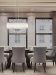Lampa wisząca Gerdo Ovale Cromo 4-punktowa w chromowanej oprawie, o prostokątnym kształcie, zawieszona na dwóch cienkich linkach. W tle elegancka jadalnia z szarymi krzesłami i dużymi oknami, na jasnym tle.