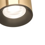 Reflektor spot Track Lea Gold w kolorze czarnym i złotym, z okrągłą głowicą. Górna część złota, dolna czarna, z widocznym kloszem emitującym światło. Ujęcie z bliska, pokazujące detal konstrukcji i fakturę powierzchni.