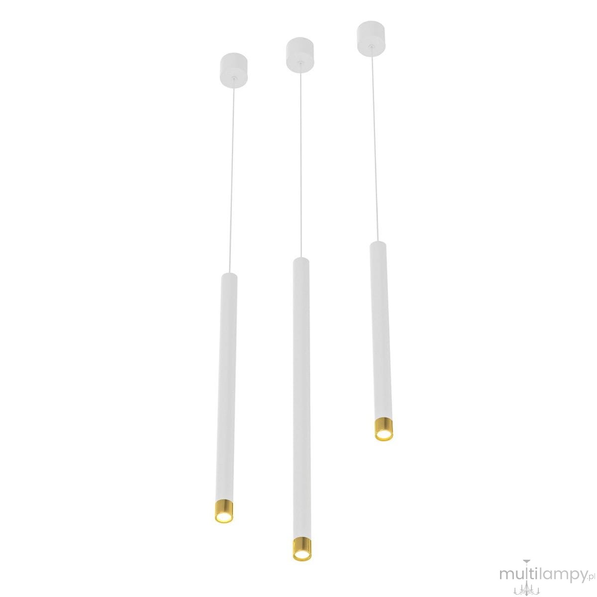 Lampa wisząca Q I Bianco/Gold 40 w kolorze białym i złotym, składająca się z trzech długich, cylindrycznych kloszy z białym wykończeniem i złotymi końcówkami, zawieszona na cienkich linkach, na jasnym tle.