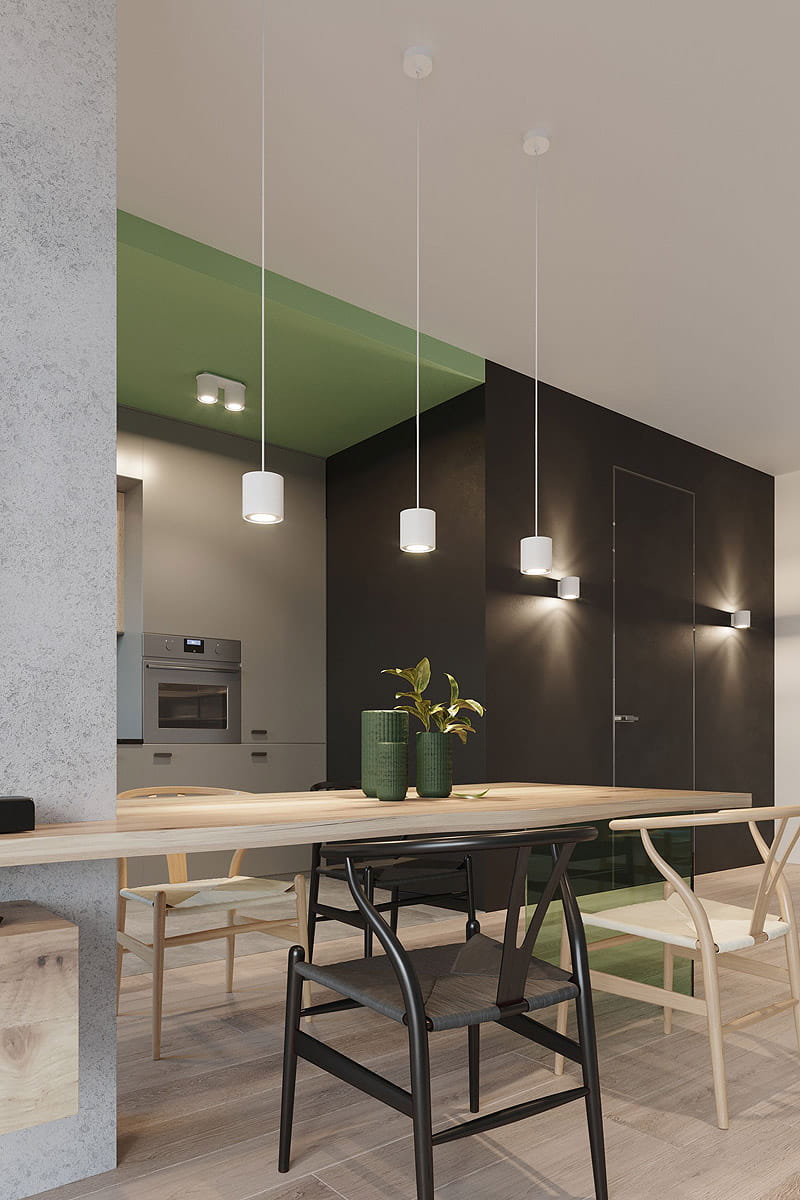 Lampa wisząca Orbis 1-punktowa w kolorze białym, zawieszona na cienkich linkach. Widoczna w nowoczesnym wnętrzu, nad drewnianym stołem. Tło w odcieniach szarości i zieleni, z elementami dekoracyjnymi na stole.