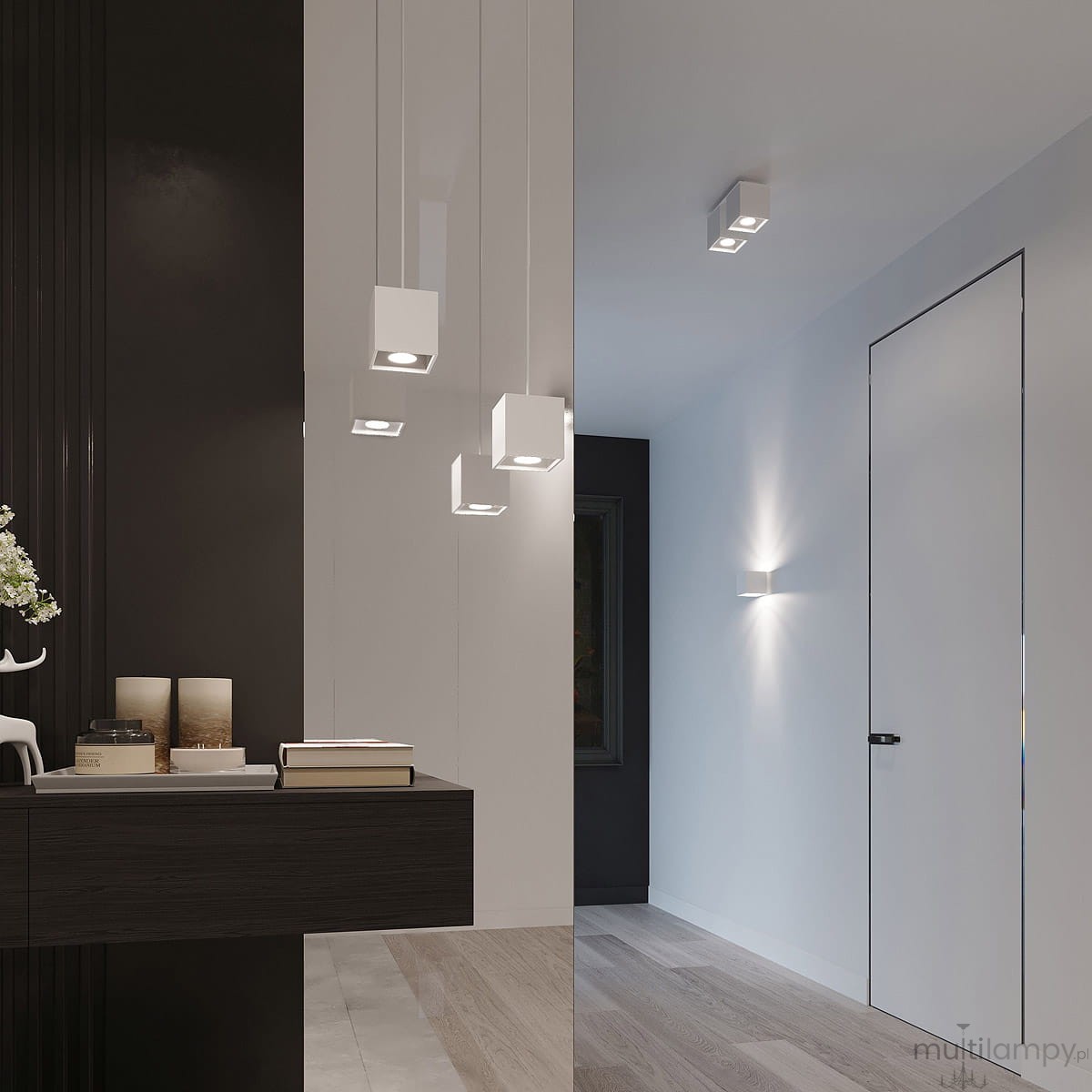 Lampa wisząca 1-punktowa w białym kolorze z kwadratowym kloszem, zawieszona na cienkim przewodzie. Ujęcie z boku, w nowoczesnym wnętrzu, obok czarnej ściany. W tle widoczne meble i drzwi.