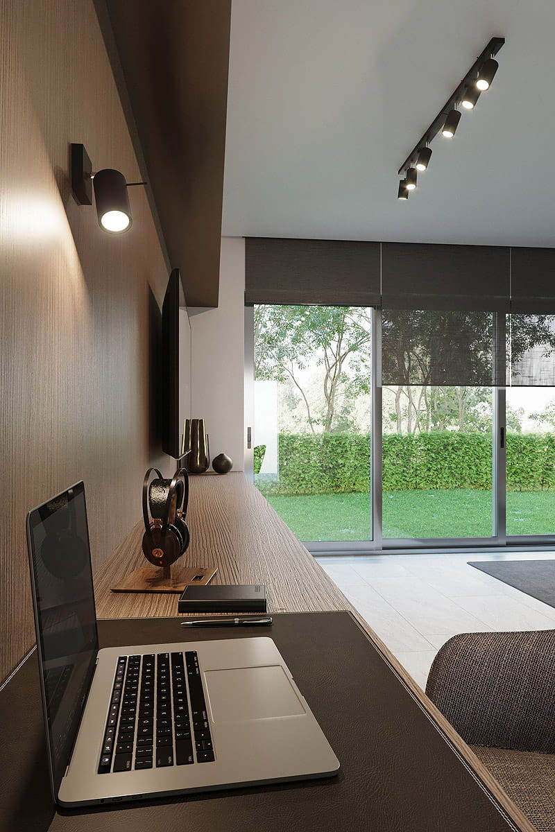 Sufitowa lampa spotowa 6-punktowa w kolorze czarnym, zamontowana na suficie. Reflektory skierowane w różnych kierunkach, metalowa konstrukcja. W tle widoczny stół roboczy z laptopem oraz okno z widokiem na zieleń.