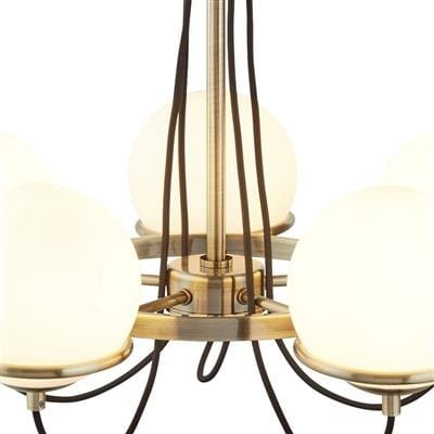 Lampa wisząca Sphere, pięciopunktowa, w kolorze antycznego mosiądzu, z białymi, okrągłymi kloszami. Produkt z widocznymi przewodami w czarnym kolorze, zawieszony na centralnej konstrukcji.