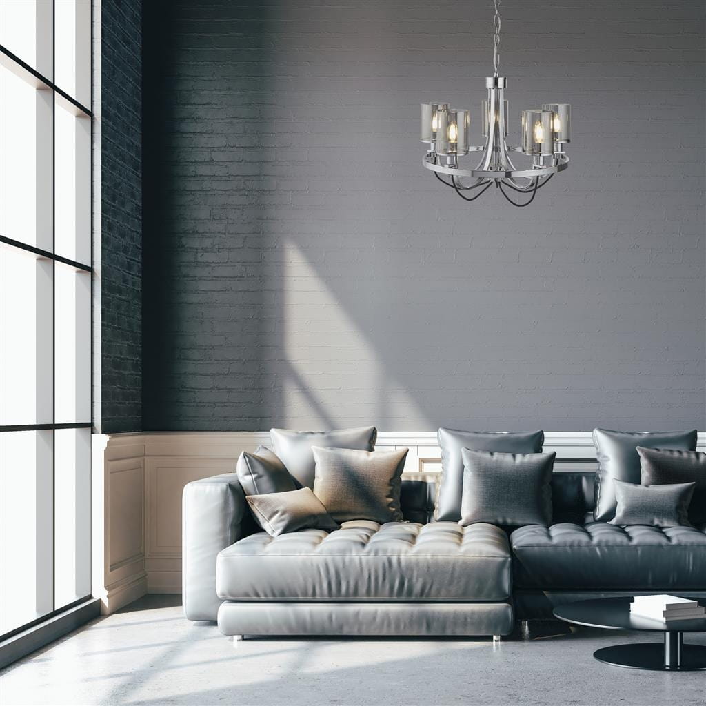Lampa wisząca Catalina 5-punktowa w chromowanej oprawie, z eleganckimi szklanymi kloszami, zawieszona w jasnym wnętrzu z nowoczesną sofą i dużymi oknami. Kąt ujęcia z przodu, ukazujący detale konstrukcji.