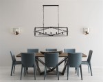 Lampa wisząca Chassis 5-punktowa w kolorze czarnym, o geometrycznej konstrukcji, zawieszona nad drewnianym stołem w jadalni. Obok znajdują się niebieskie krzesła i ścienne lampy.