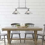 Lampa wisząca Bistro 2-punktowa w satynowym srebrze, zawieszona nad drewnianym stołem. W lampie widoczne dwa klosze w formie mis, z metalowym wykończeniem.
