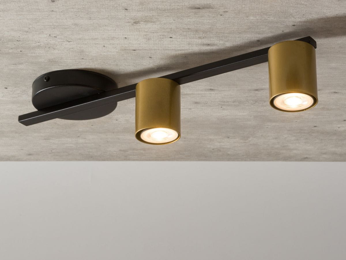 Lampa sufitowa Sky 2-punktowa w kolorze czarnym i złotym. Posiada dwa okrągłe klosze w złotym kolorze zamontowane na prostokątnej czarnej podstawie. Ujęcie z góry, ukazujące montaż do sufitu.